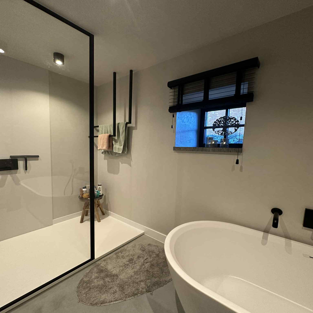 Modern bathroom with a freestanding bathtub, glass shower enclosure, and window.