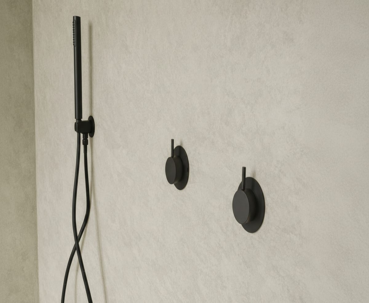Black shower head and control handles mounted on a beige tiled wall. with microfloor Beton cere